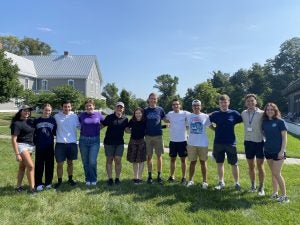 A group of students standing on a lawn on a sunny day