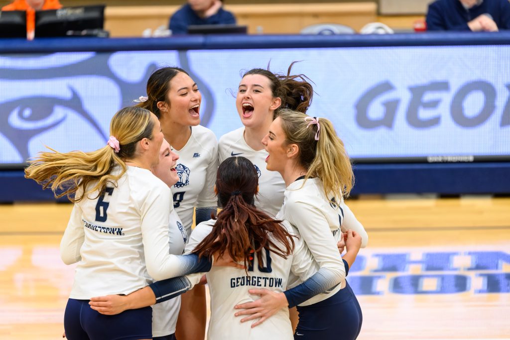 Women's volleyball players celebrating on the court