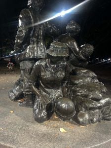 The Vietnam Womens Memorial lit up against the night sky