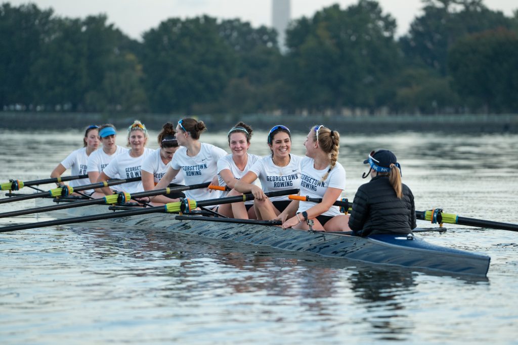 A team of female students row on a river in Virginia.