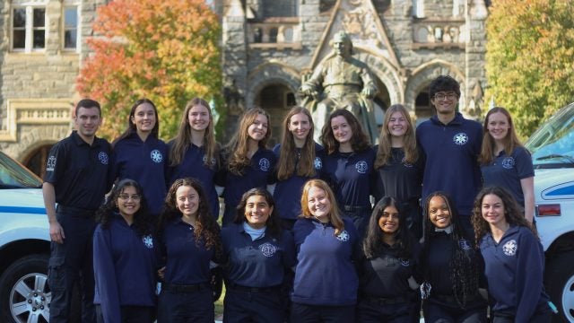 The volunteers for the student-run ambulance service, GERMS, pose together in front of Healy Hall in the fall.