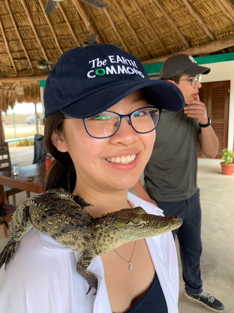 a girl with a crocodile on her shoulder