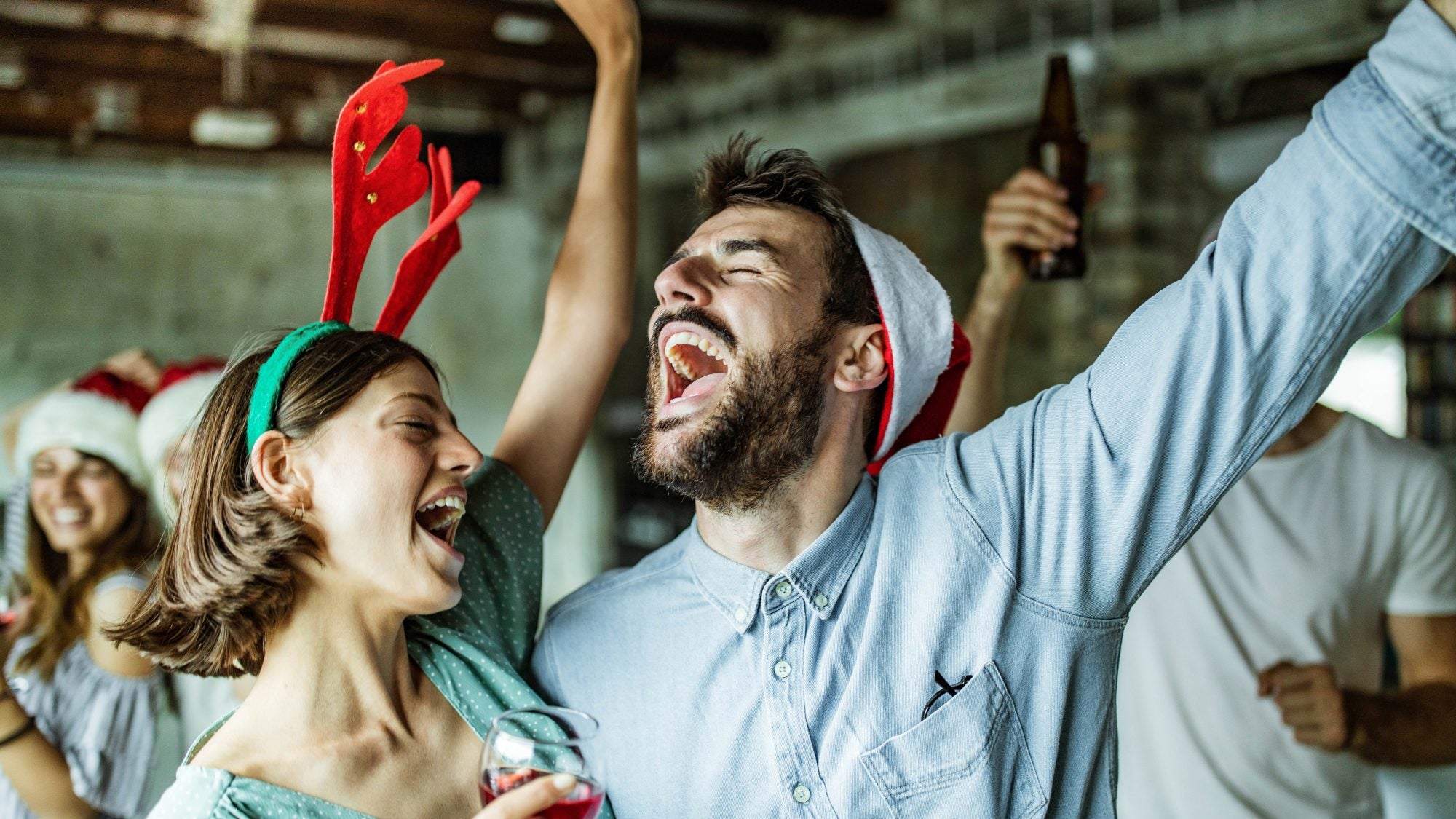 Happy couple having fun while singing on Christmas party.