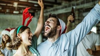 Happy couple having fun while singing on Christmas party.