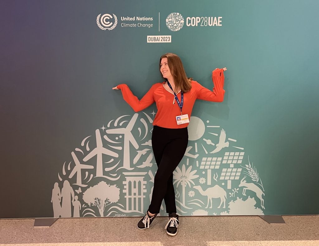 Woman standing with a COP 28 sign