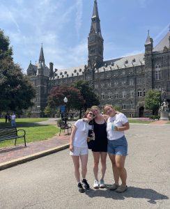 Three girls pose and smile for a picture in Healy Circle
