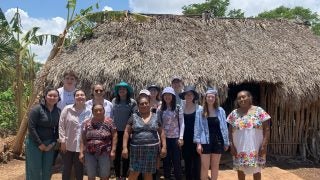 Group of students in front of a hut