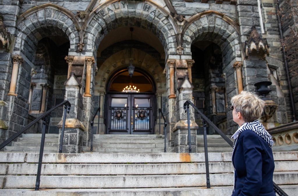 A woman looks up at the arches of Healy Hall on Georgetown's Main Campus.