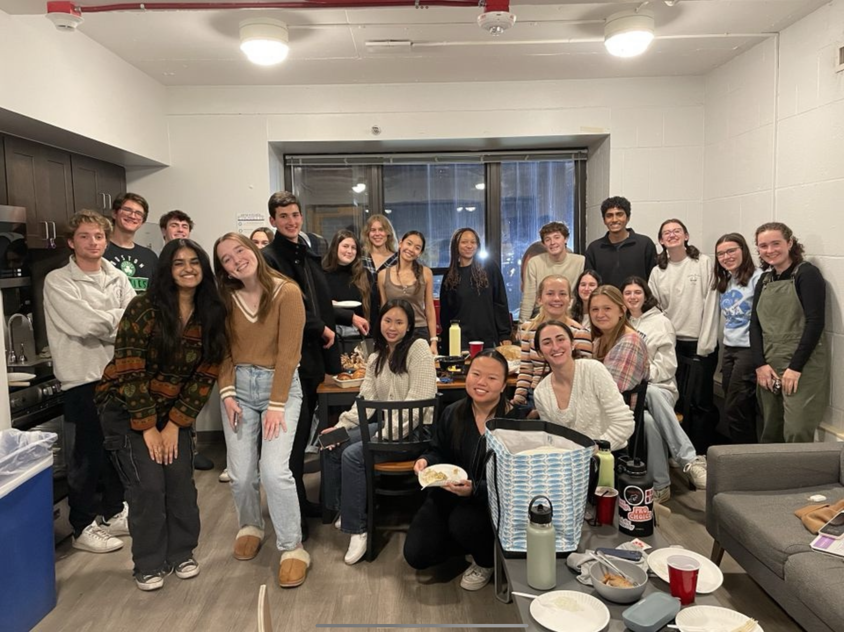 A group of students standing around a table for friendsgiving