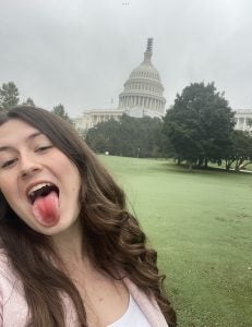 A young woman in front of the U.S. Capitol on a cloudy day