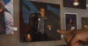 A Black alumnus of Georgetown points to a picture of him performing in a play during his undergraduate years that's posted in a theater on-campus.