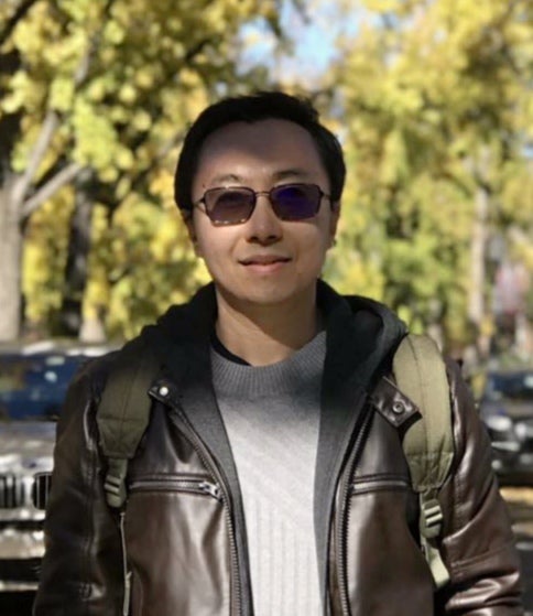 Professor Song Gao, wearing jacket and sunglasses, looking at camera.