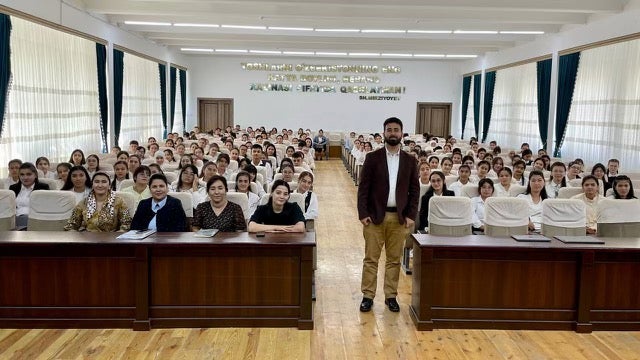 A man stands with a class full of students