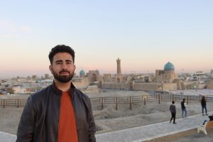 Young man standing with the Bukhara city skyline behind him