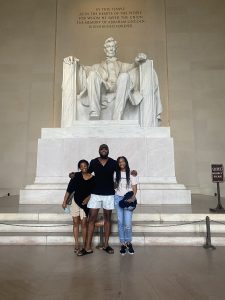 From left to right: Christine's mom, Christine's brother, and Christine smile for a group photo in front of the Lincoln Memorial