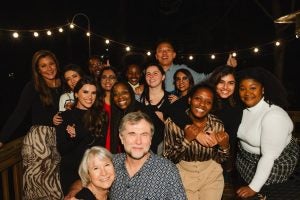 Dubova and a group of her classmates standing at night outside with an elderly couple