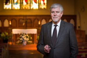 John Glavin in a suit in Dahlgren Chapel