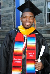 A young Black man in graduation robes