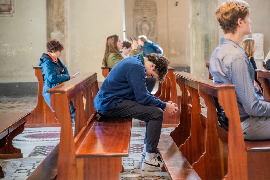 Person in a pew praying with head bowed