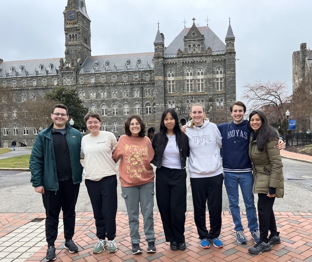A group of young people in front of Healy Hall on a cloudy day