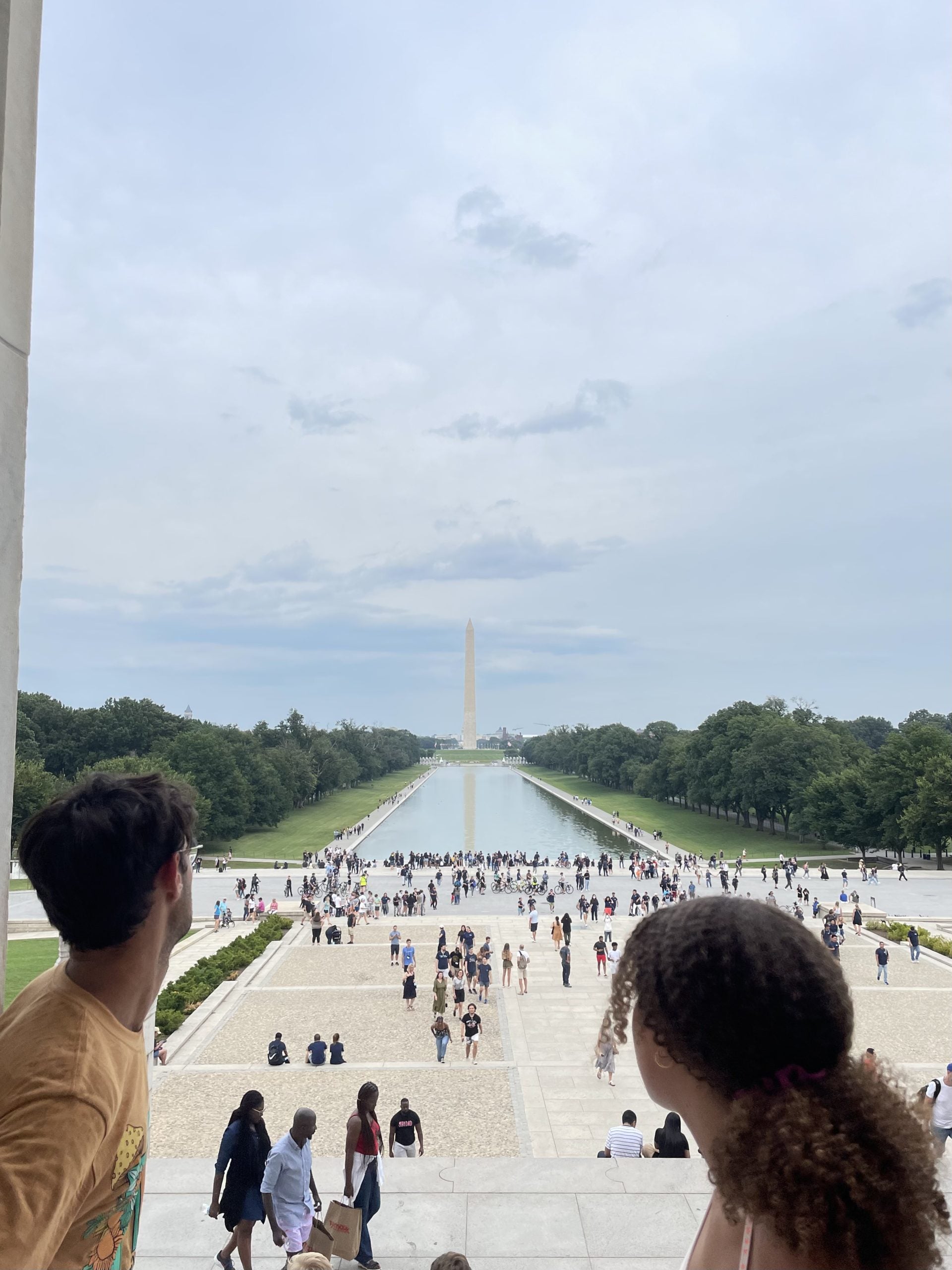 Two friends look out over the reflecting pool and National Monument from the Lincoln Memorial