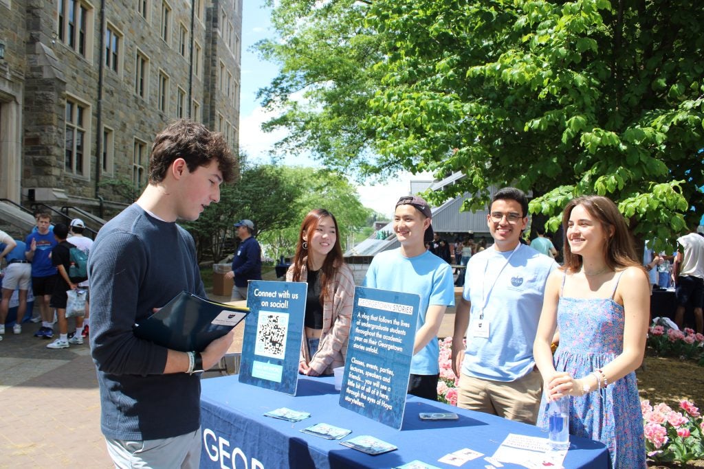 Admitted student learning more about Georgetown’s clubs and organizations at the mini club fair