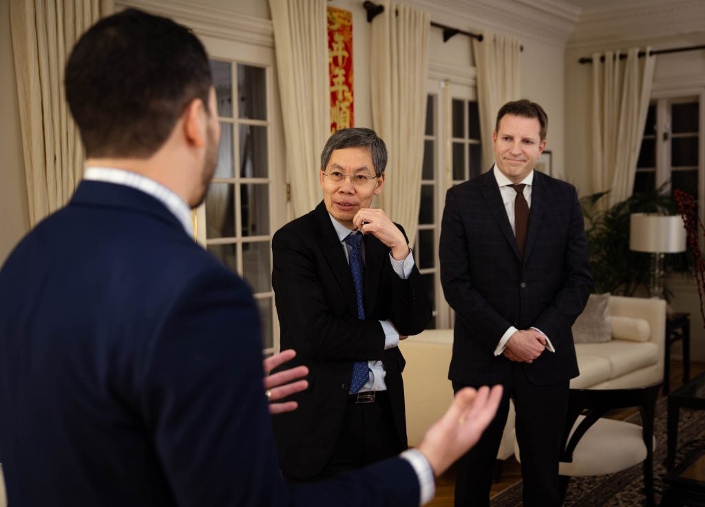 The Singaporean Ambassador looks while speaking to a man whose back is to the camera