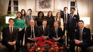 A group photo of people in formal attire at the Singaporean residence