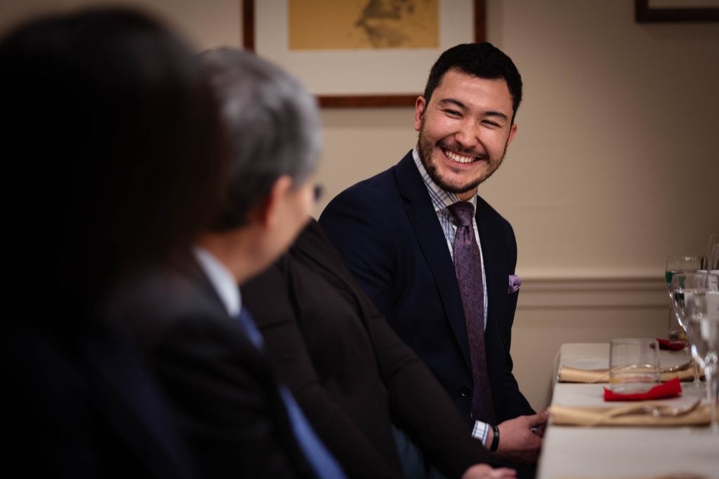 A man smiles while looking at the Singaporean ambassador