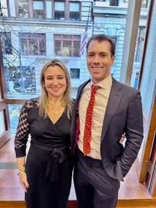 A young man and woman standing together in formal attire.