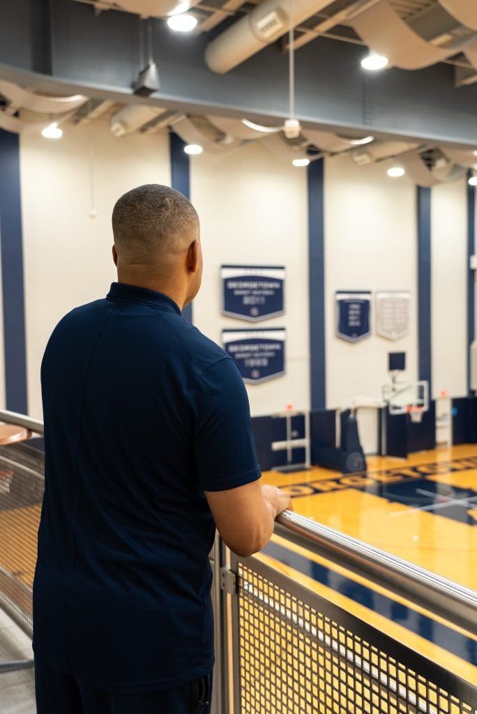 Women's Basketball Coach Darnell Haney stares out over a ledge of Georgetown's practice facility.