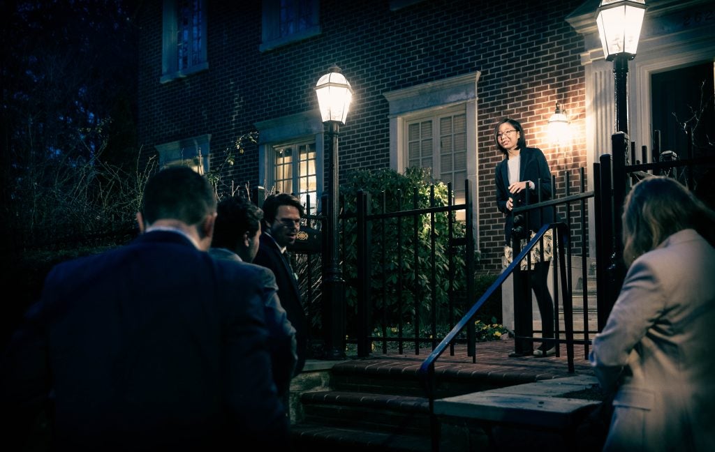 A group of people being let into the ambassador's house at night