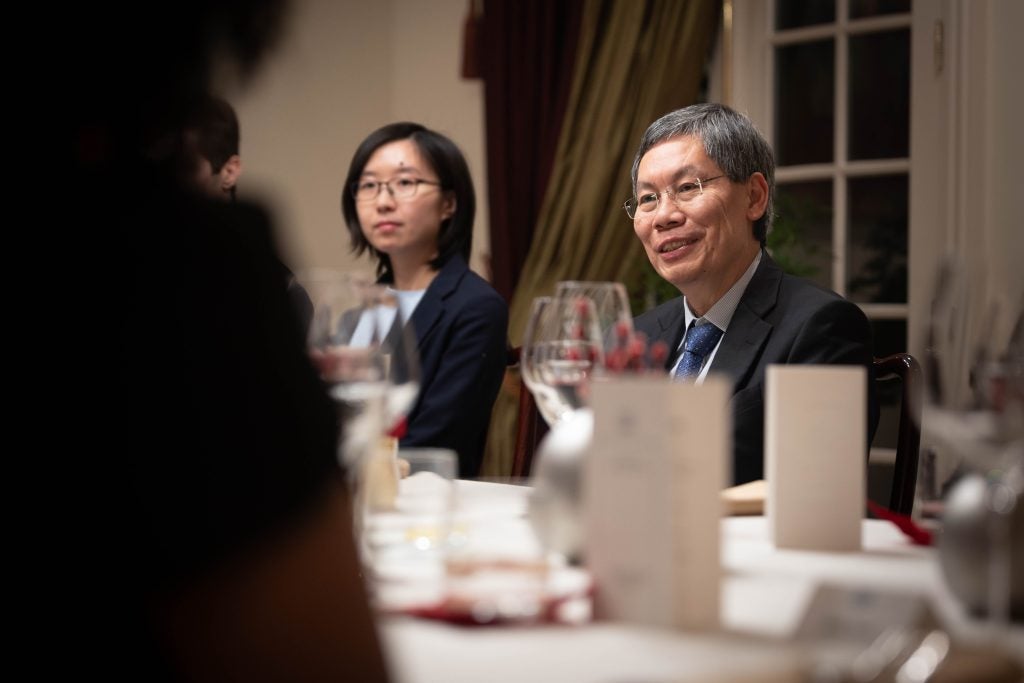 A man at a table looking at someone as they speak