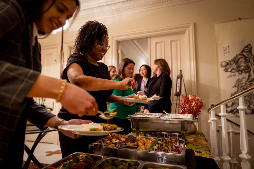 A group of students in formal attire getting food from a buffet station