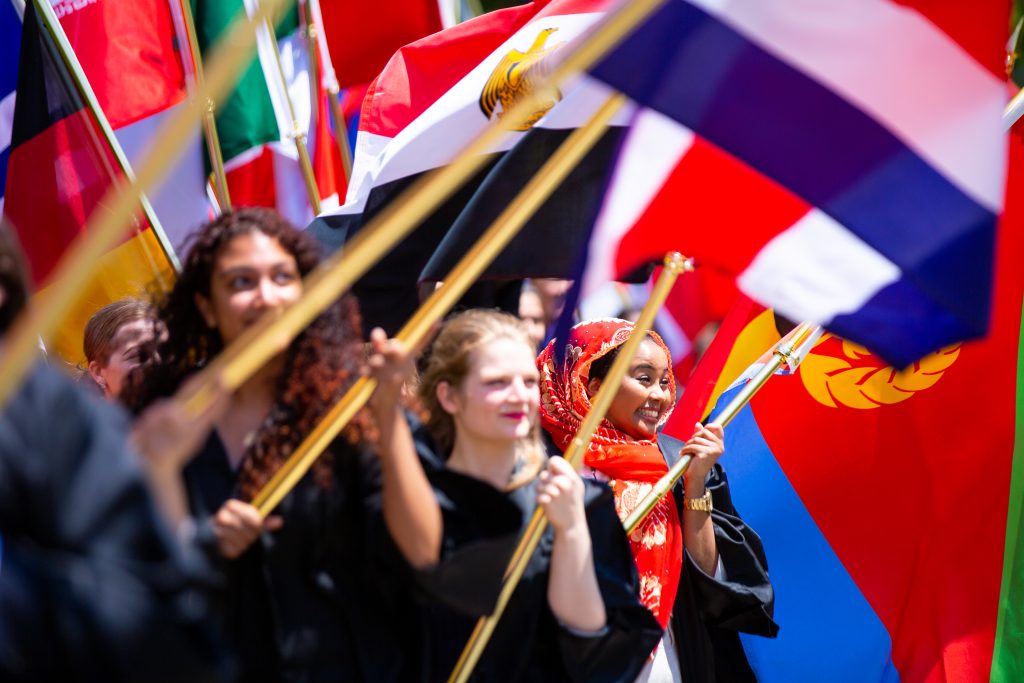 A group of students carry flags on their graduation day.