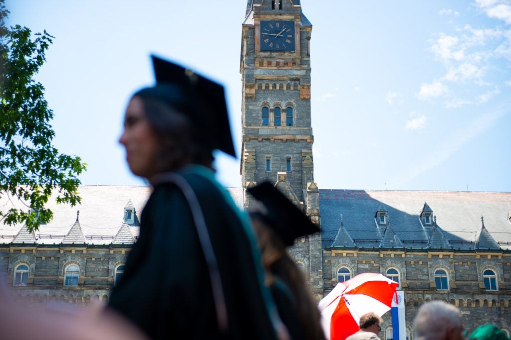 A motion blurred student passing by Healy on a sunny day