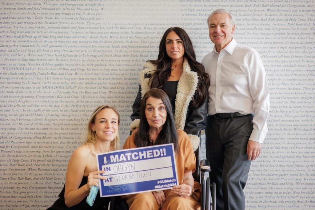 A young woman and her family on match day with a sign