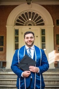 Adam Hamdan (C’24) posing for his graduation photo in front of Old North.