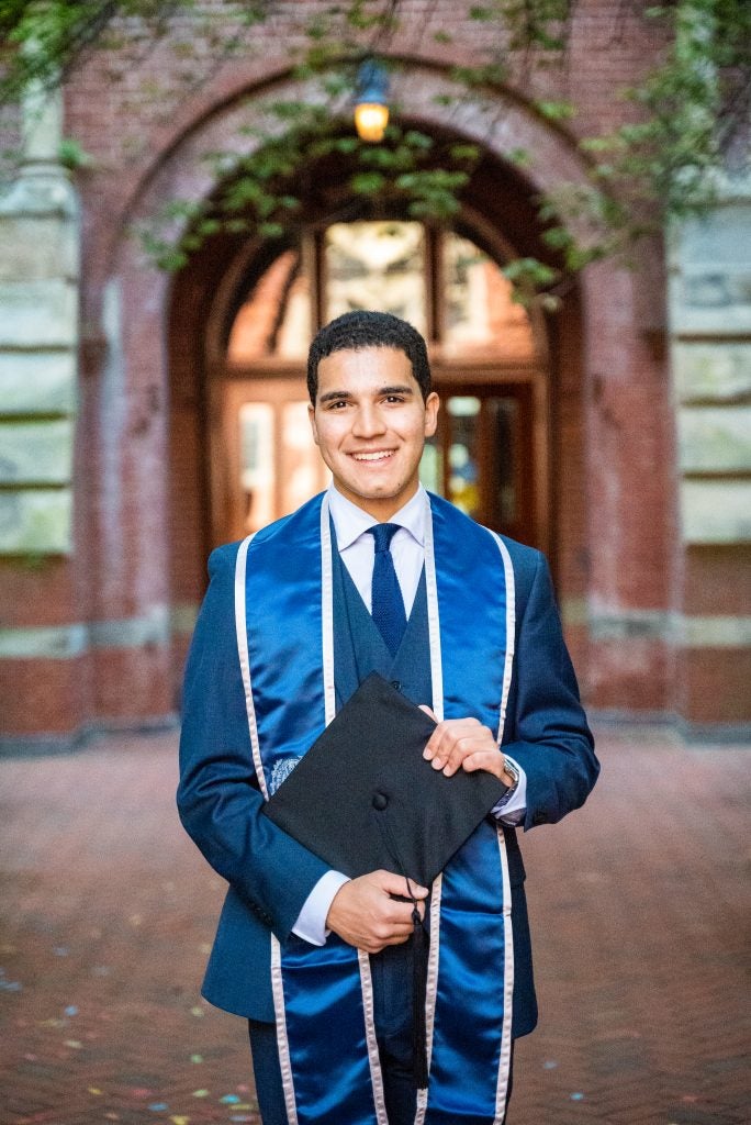 Marco Perez (SFS’24, G’26) posing for his graduation photo in Dahlgren Quad. 
