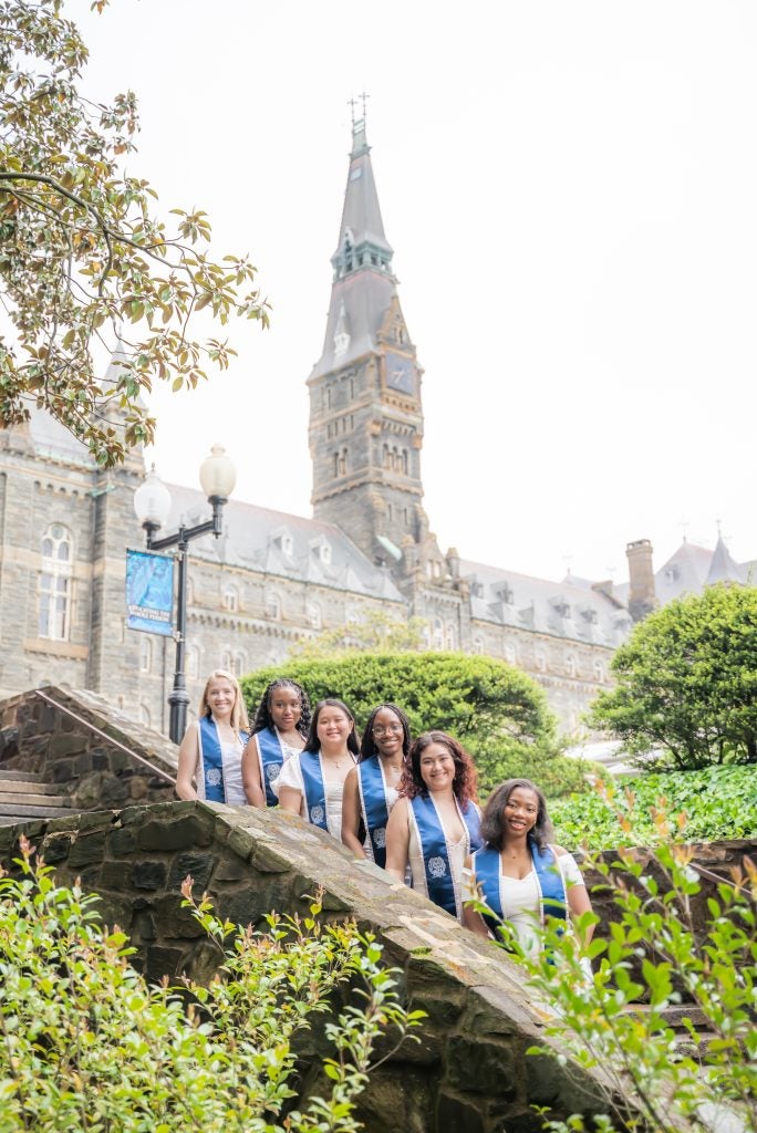 Christine Mauvais (N’24) and her friends posing for their graduation photo on the Lauinger Steps.