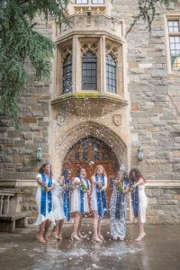 Christine Mauvais (N’24) and her friends celebrate their graduation by popping champagne bottles in front of White Gravenor.