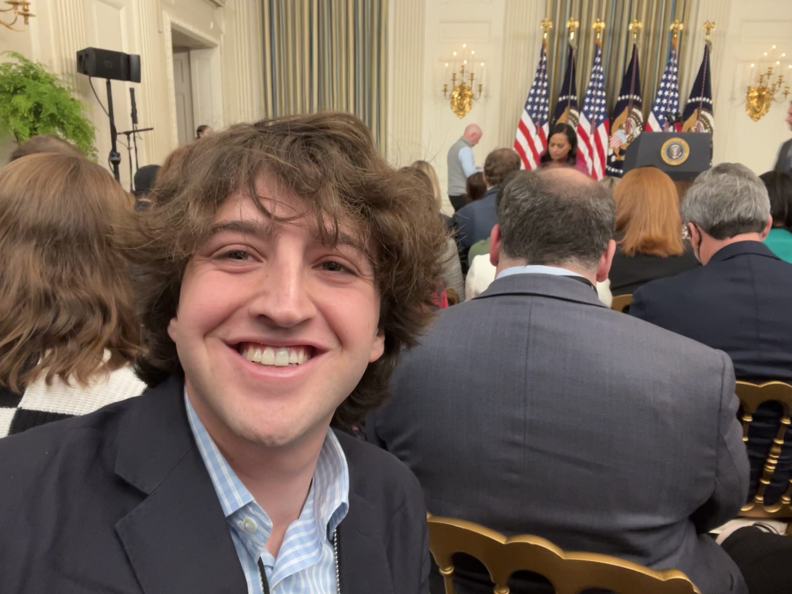 A selfie of Fleisher with the White House Press Corps and the podium of the president behind him.
