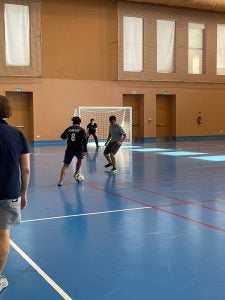 A group of young men playing soccer in an indoor gym