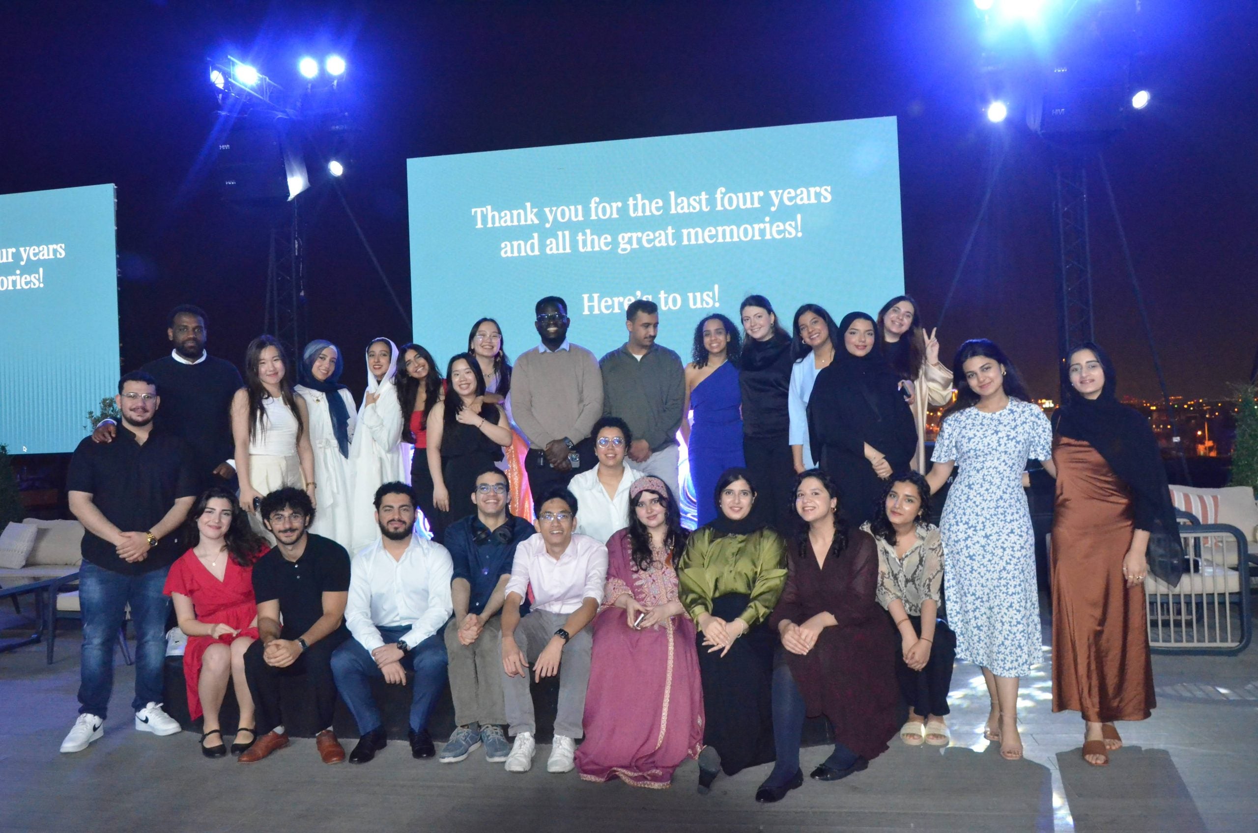 GU-Q seniors standing on stage at the senior dinner