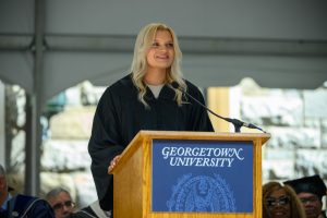 Lisa Kennedy in convocation robes speaking at a podium