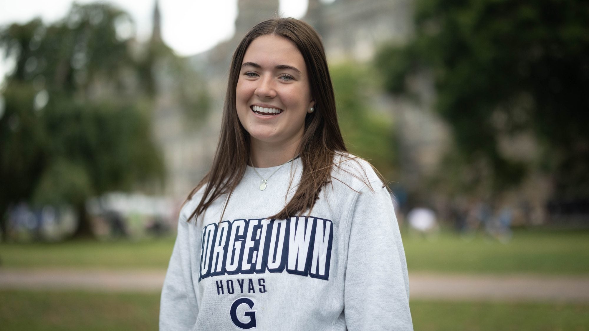 Sarah Brannigan wearing a light grey GU sweatshirt on Healy Lawn