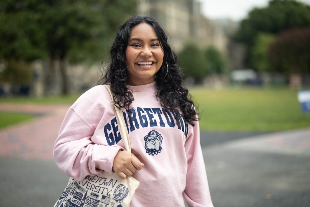 Mara Goldstein in a pink GU crewneck sweatshirt on Healy Lawn