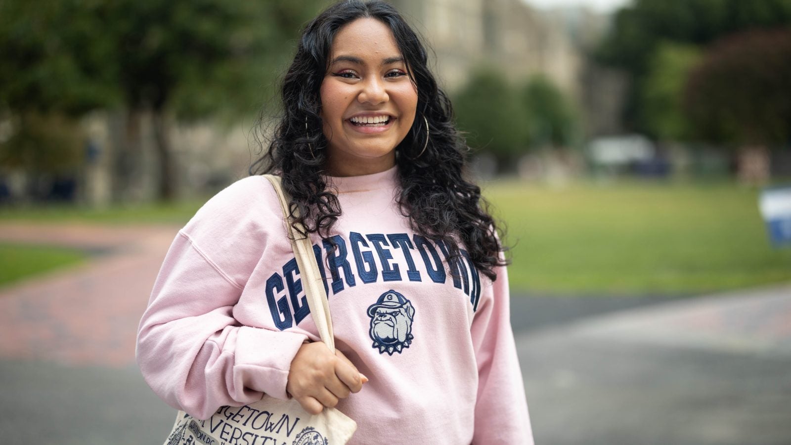 Mara Goldstein in a pink GU crewneck sweatshirt on Healy Lawn