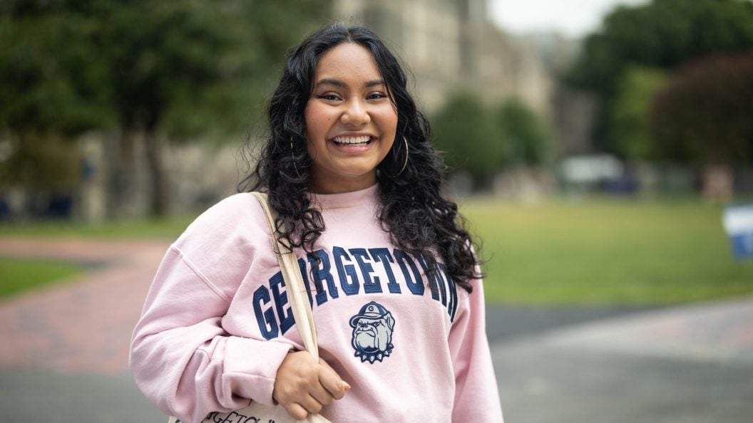 Mara Goldstein in a pink GU crewneck sweatshirt on Healy Lawn