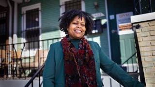 Paula Thompson, CEO and president of Voices for a Second Chance, stands on the steps outside the door to her office's home-like headquarters.